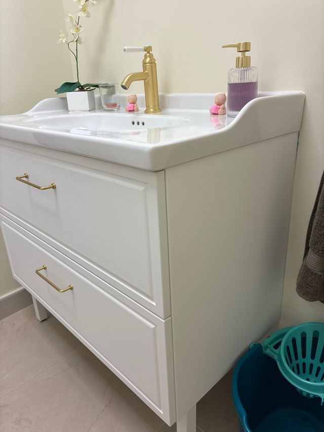 Mueble de baño con lavabo y grifería dorada