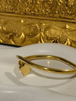 Pulsera dorada con diseño de trébol