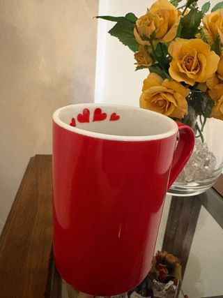 Tazza rossa con cuori bianchi
