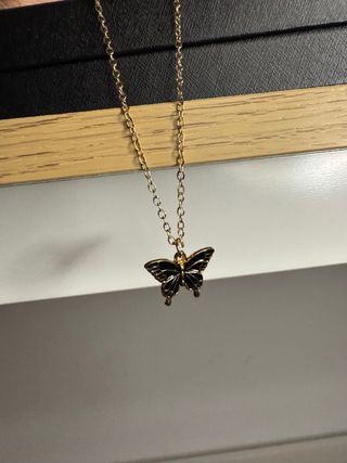 Collar dorado con mariposa negra