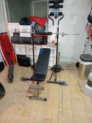 Banco de musculación con barra y pesos