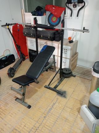 Banco de musculación con barra y pesos