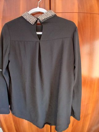 Blusa negra con cuello pedrería .
