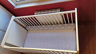 Cuna de bebé blanca con osito y estrellas