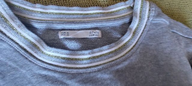 Sudadera gris con cuello plateado y dorado