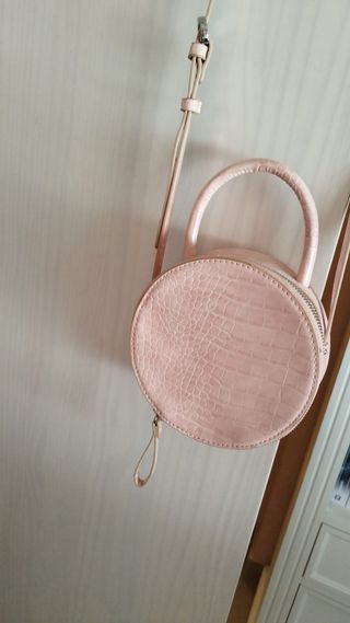 Bolso circular rosa con correa