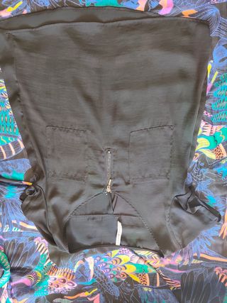 Blusa negra con cremallera y bolsillo.