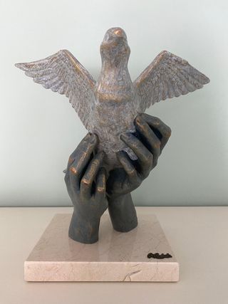 Escultura de manos con paloma
