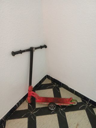 Patinete rojo con rueda de repuesto