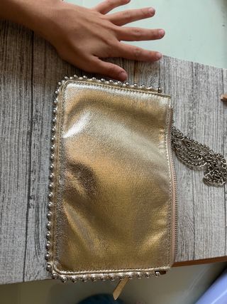 Bolso de mano dorado con cadena