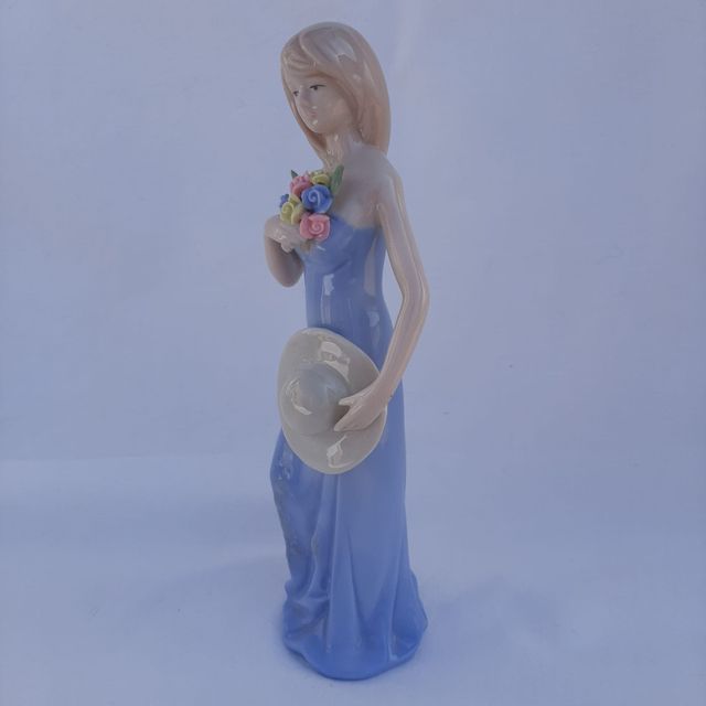 Figura de porcelana con flores y sombrero