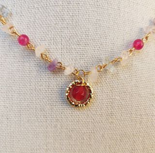 Collana dorata con pietre bordeaux
