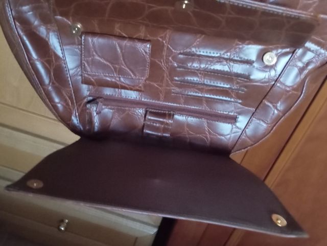 Bolso de mano marrón con textura un poco rígida 
