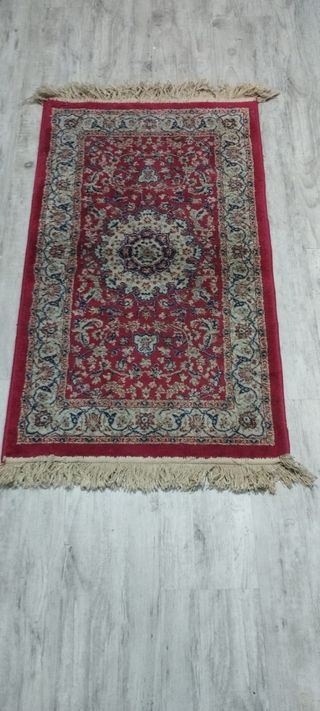Alfombra de cama roja con flecos