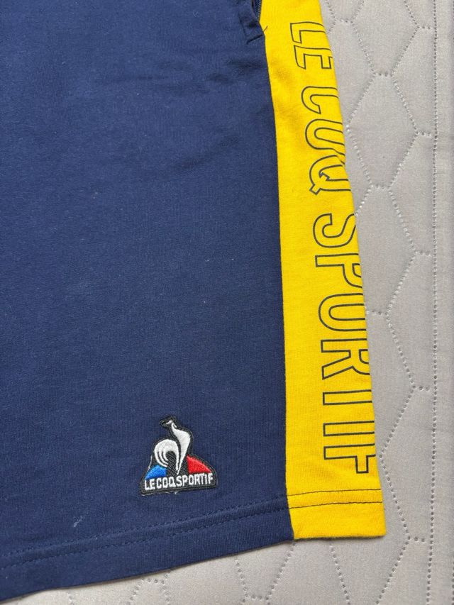 Le Coq Sportif Pantalón Corto Azul y Amarillo