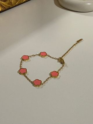 Pulsera dorada con flores rosas
