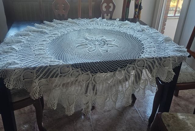 Tapete redondo de ganchillo blanco.