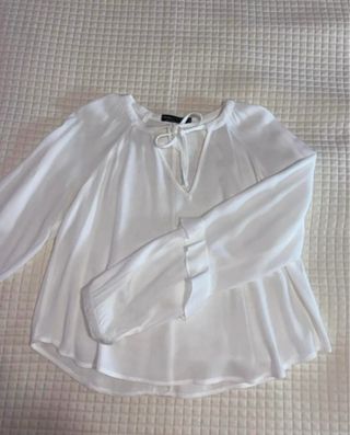 Blusa blanca de manga larga con lazo en el cuello