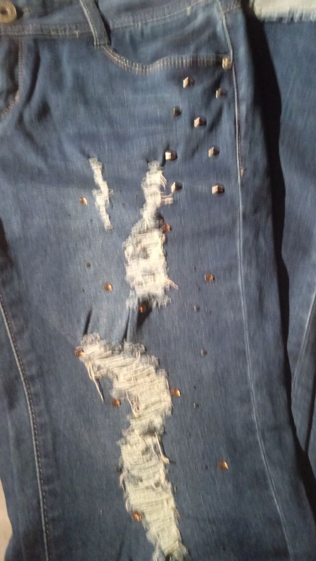 Calças elásticas rasgadas com tachas