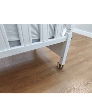 Cuna de madera blanca con ruedas
