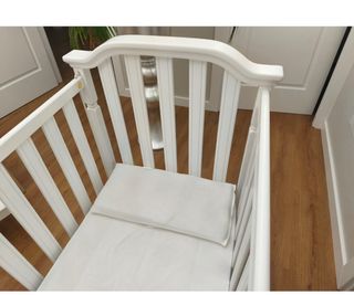 Cuna de madera blanca con ruedas