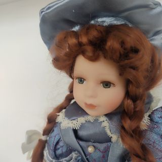 Muñeca de porcelana con armario y ropa