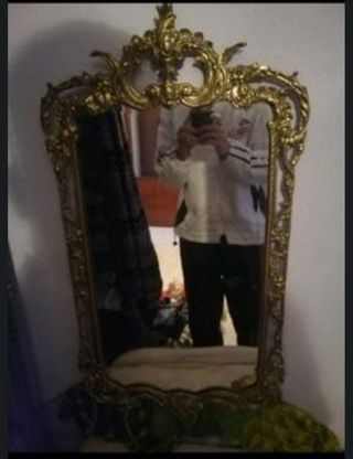 Espejo de pared dorado con marco ornamentado