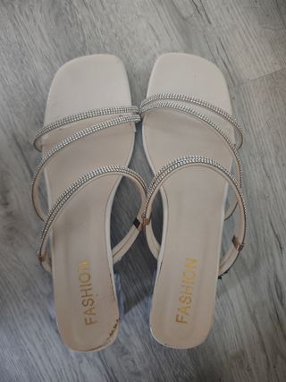 Sandalias beige con tiras de pedrería poco tacón.