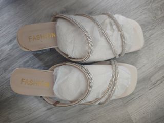 Sandalias beige con tiras de pedrería poco tacón.