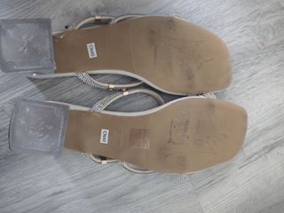 Sandalias beige con tiras de pedrería poco tacón.