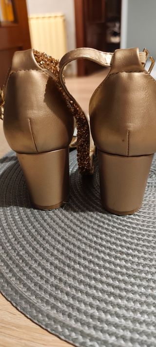 Zapatos dorados rosados de pulsera y tacón