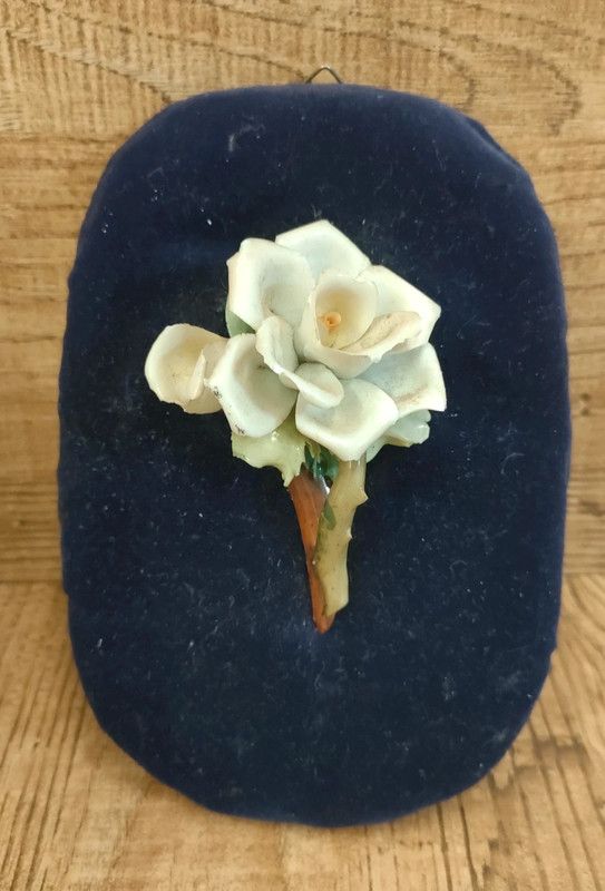 Rosa bianca ceramica su velluto blu