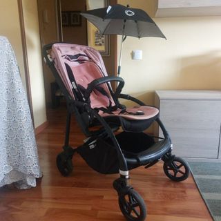 Carro de bebé rosa con sombrilla