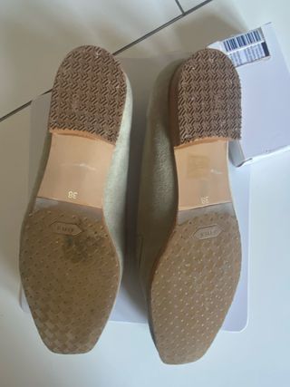 Zapatos planos mujer verde con detalle dorado.