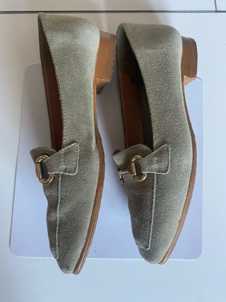 Zapatos planos mujer verde con detalle dorado.