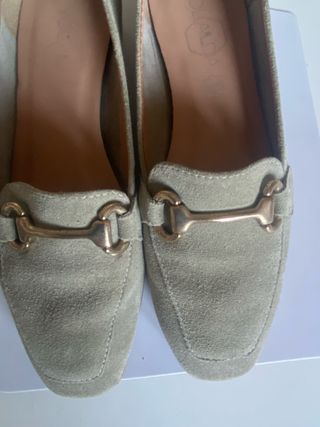 Zapatos planos mujer verde con detalle dorado.