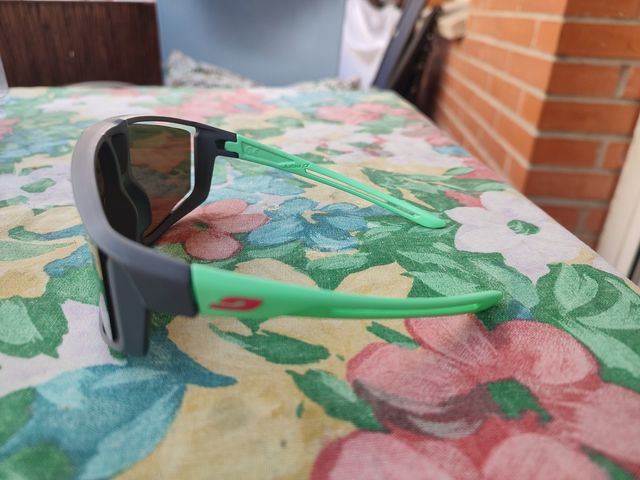 Gafas de sol Julbo infantiles grises y naranjas.