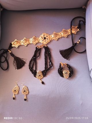 Colgante y pendientes dorados con detalles rojos