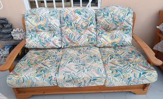 Sofá y sillón de madera con cojines estampados