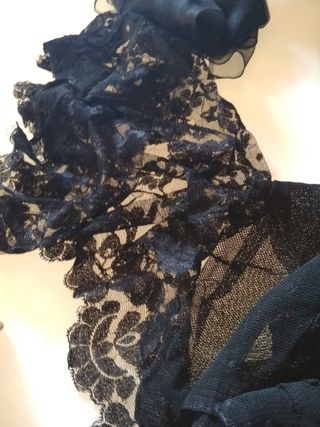 Diverse coperte in pizzo nero per oggetti di scena