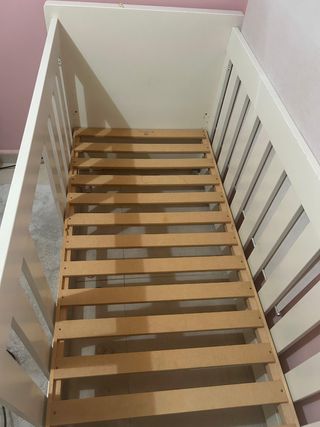 Cuna de madera para bebé con colchón y funda.