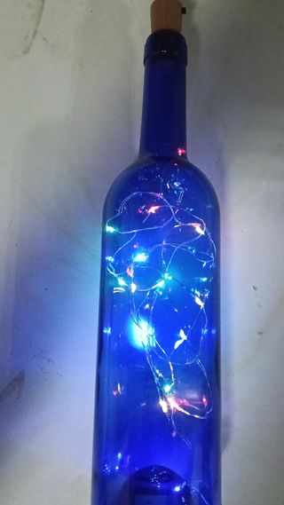 Botella azul decorativa con luces LED