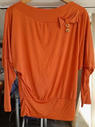 Camisa naranja con lazo y charm