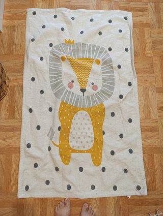 Alfombra infantil león beige y amarillo.