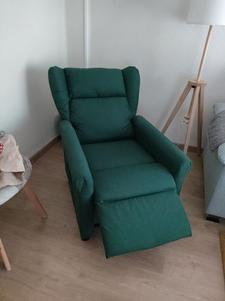 Sillón reclinable eléctrico de tela verde.