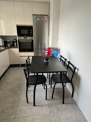 Mesa de cocina negra con sillas