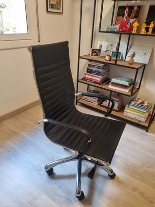 Sillón de oficina negro con ruedas. Piel sintética