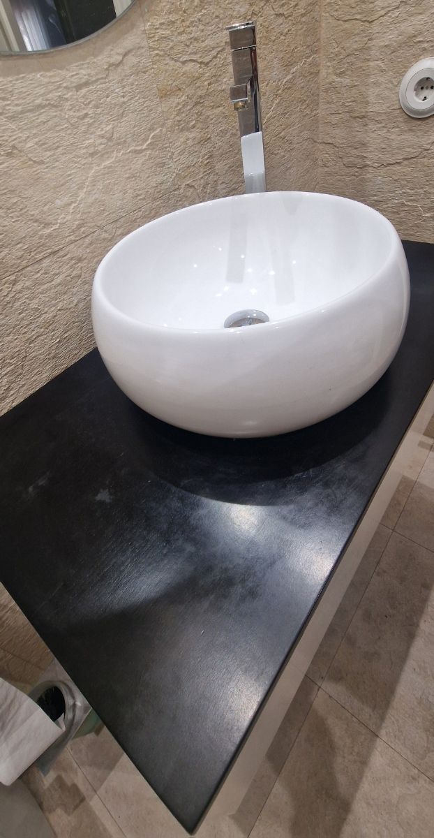 Mueble de baño con lavabo de cerámica.