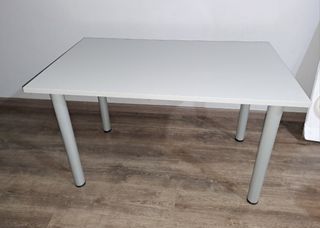 Mesa gris con patas metálicas.