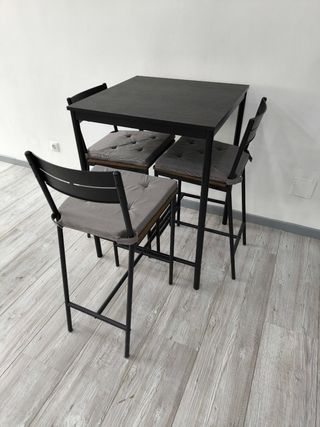 1 Mesa alta y 3 sillas negras con alcochados.